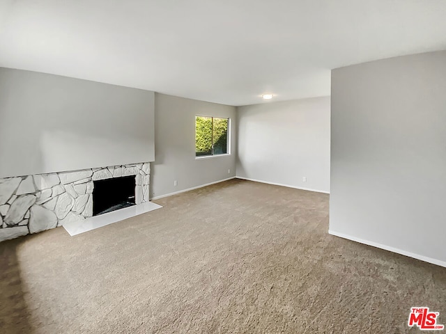 unfurnished living room with a fireplace and carpet flooring