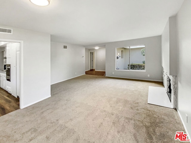 unfurnished living room with dark carpet