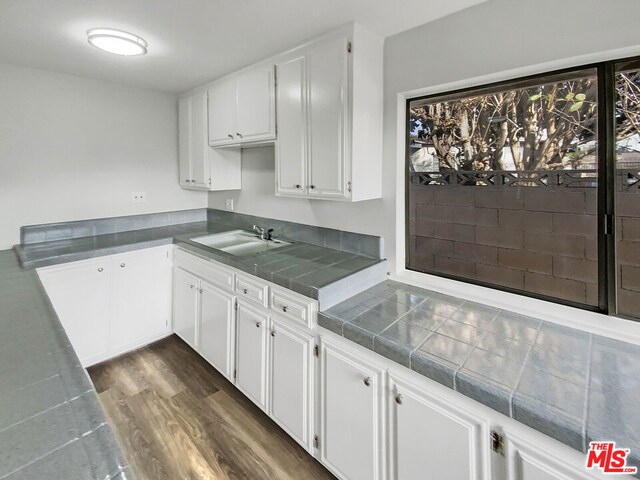 kitchen featuring tile countertops, sink, dark wood-type flooring, and white cabinets