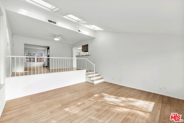 spare room featuring hardwood / wood-style flooring, a skylight, and ceiling fan