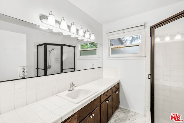 bathroom with plenty of natural light, decorative backsplash, a shower with shower door, and vanity