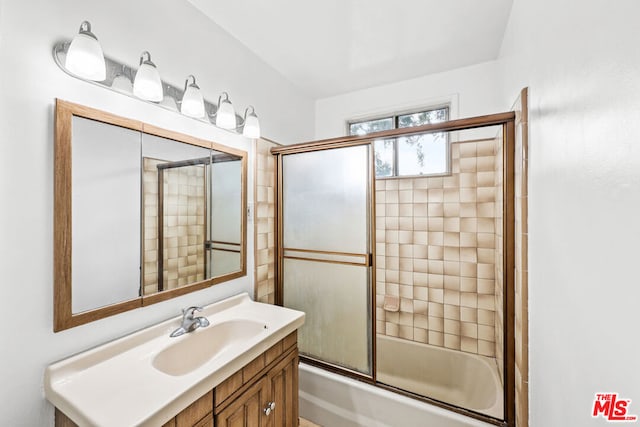 bathroom featuring vanity and shower / bath combination with glass door