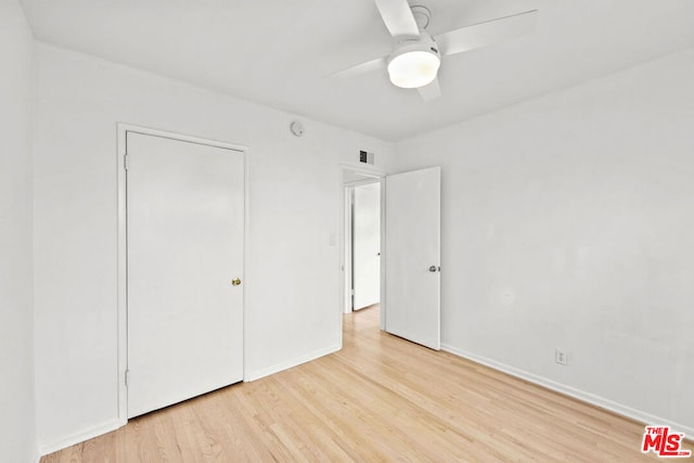 unfurnished bedroom featuring light wood-type flooring, a closet, and ceiling fan