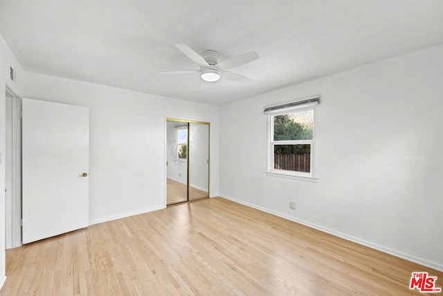 unfurnished bedroom featuring ceiling fan, light hardwood / wood-style floors, and a closet