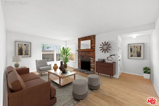 living room with hardwood / wood-style floors and a brick fireplace