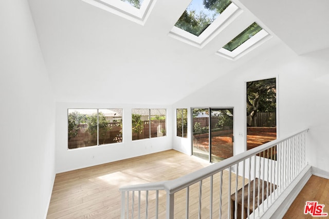 unfurnished sunroom with vaulted ceiling with skylight