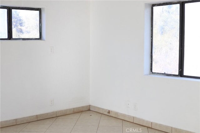 tiled spare room featuring plenty of natural light