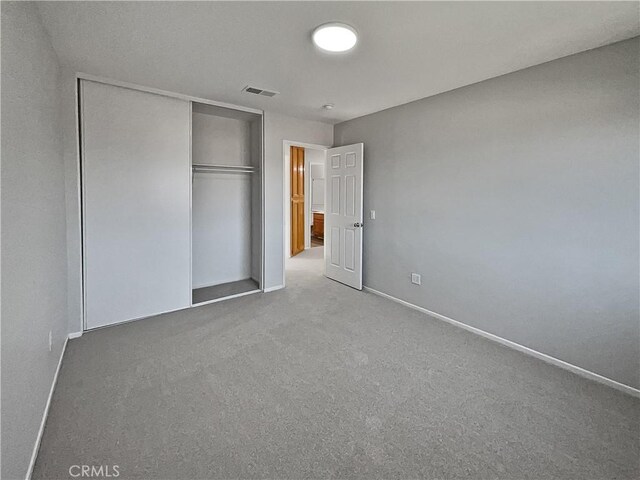 unfurnished bedroom with a closet and carpet flooring