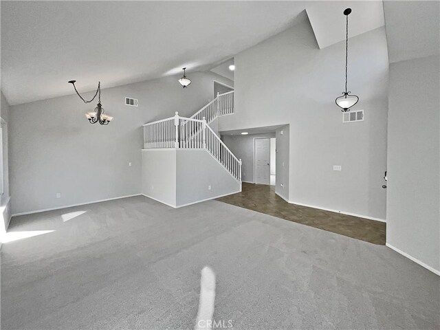 unfurnished living room featuring a notable chandelier, carpet floors, and high vaulted ceiling