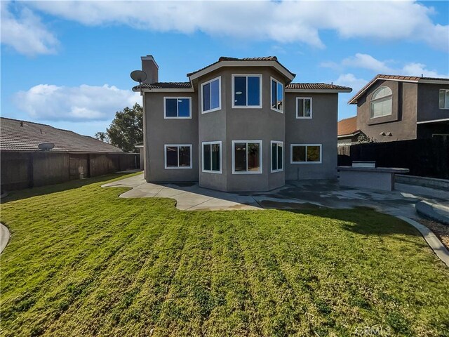 back of house featuring a patio and a yard