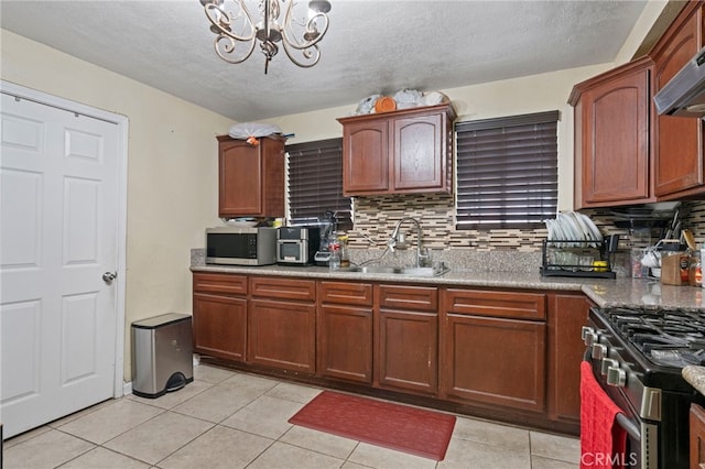 kitchen featuring tasteful backsplash, sink, light tile patterned floors, a notable chandelier, and stainless steel appliances