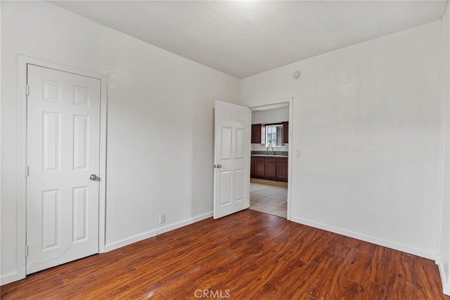 unfurnished room featuring sink and light hardwood / wood-style floors