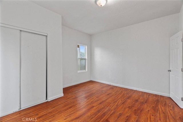 unfurnished bedroom with hardwood / wood-style flooring and a closet