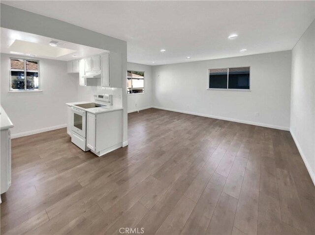 kitchen featuring wood-type flooring, white cabinets, and white range with electric stovetop