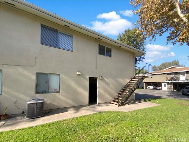 back of property with a lawn and central air condition unit