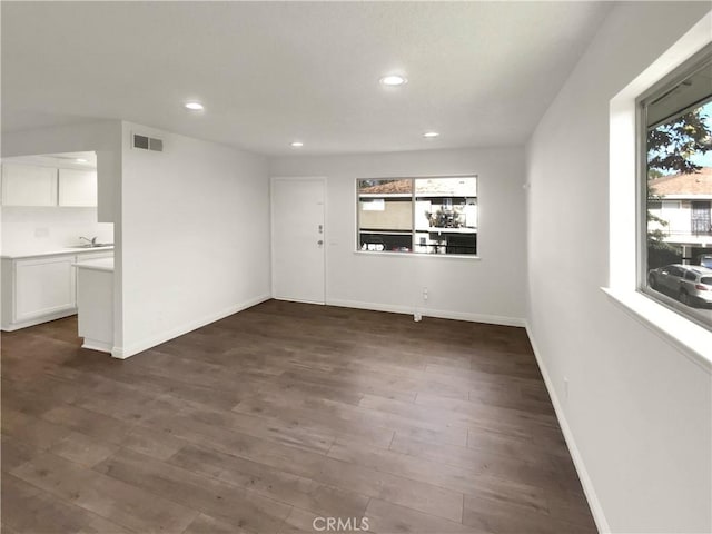 interior space with baseboards, recessed lighting, dark wood-style floors, and visible vents