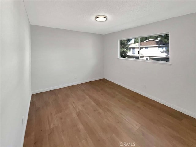 empty room featuring a textured ceiling and hardwood / wood-style flooring