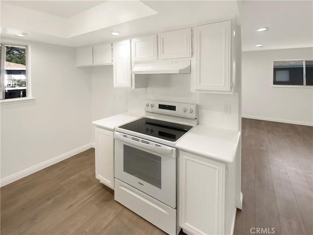 kitchen featuring light hardwood / wood-style floors, white electric stove, white cabinets, and a tray ceiling