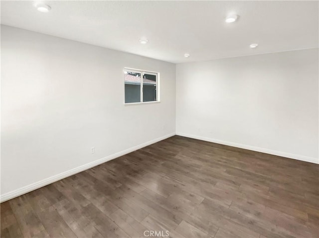 empty room with recessed lighting, baseboards, and wood finished floors