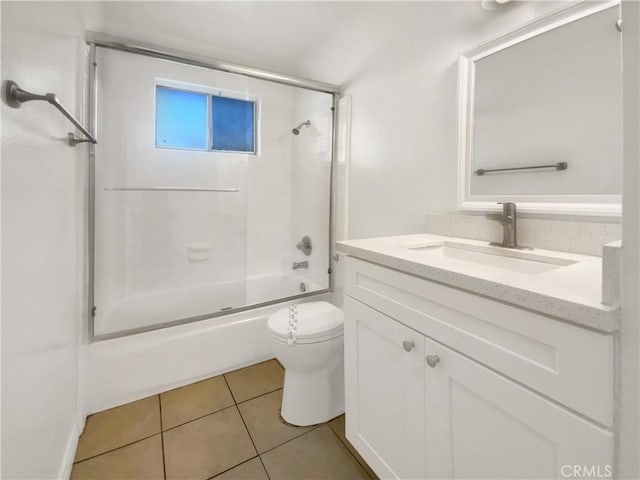 full bathroom with combined bath / shower with glass door, vanity, toilet, and tile patterned flooring