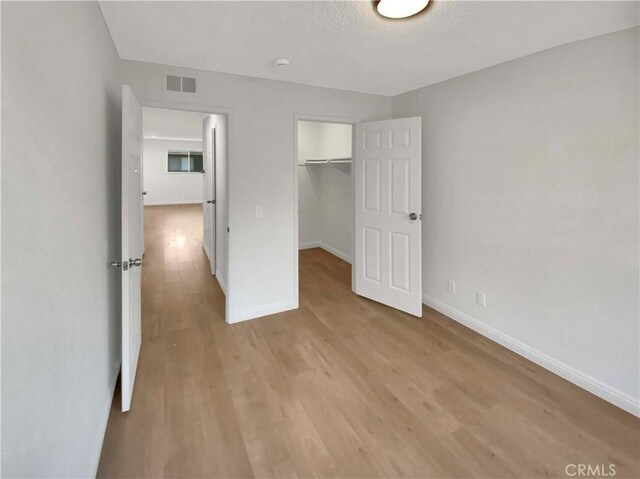 unfurnished bedroom featuring a closet and light wood-type flooring