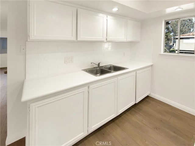 kitchen featuring dark wood-type flooring, white cabinets, and sink