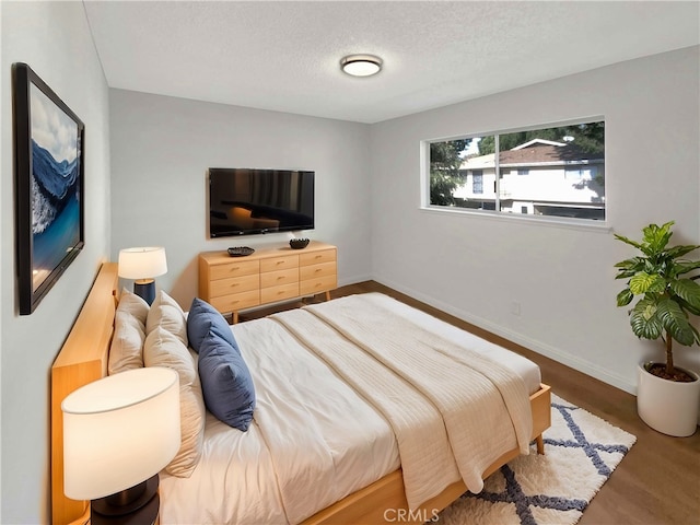 bedroom with wood-type flooring and a textured ceiling