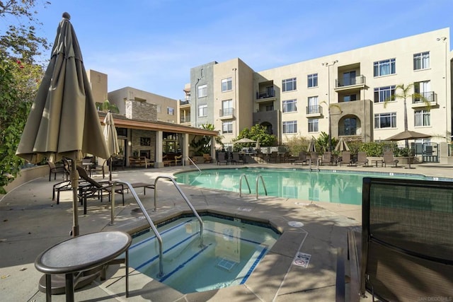 view of swimming pool with a hot tub and a patio area