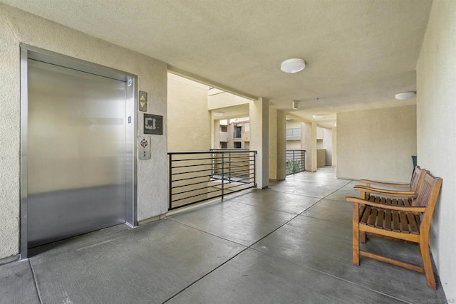 hall with concrete floors and elevator