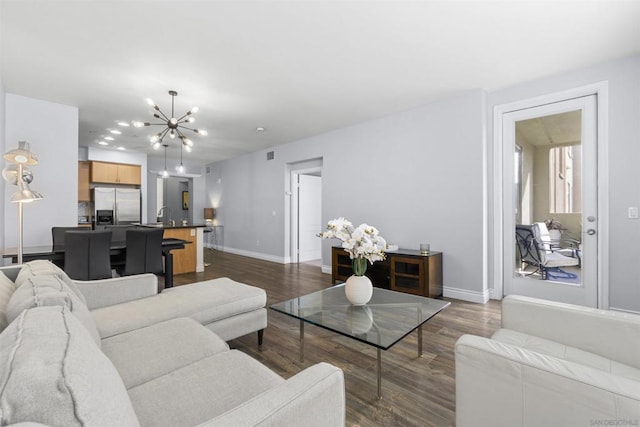 living room with an inviting chandelier, dark hardwood / wood-style floors, and sink