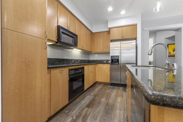 kitchen featuring dark stone countertops, black appliances, decorative backsplash, sink, and dark hardwood / wood-style flooring