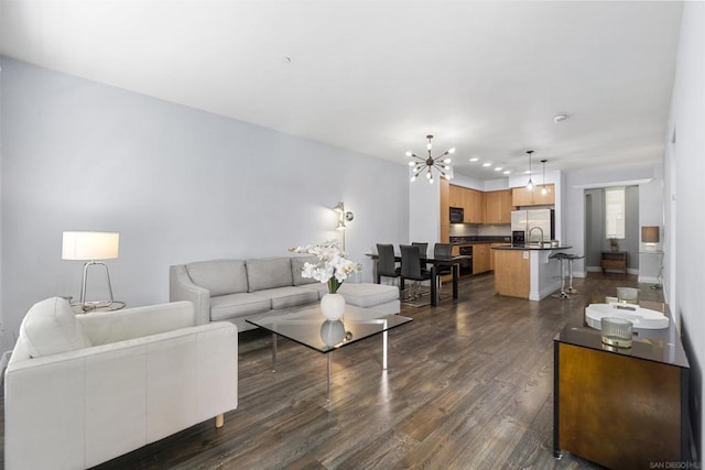 living room featuring dark hardwood / wood-style flooring and an inviting chandelier