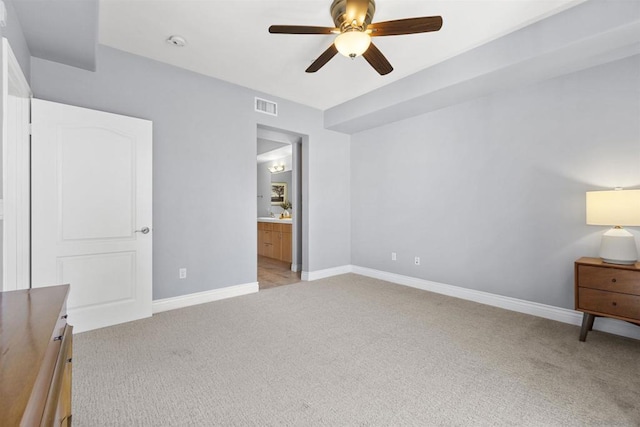 unfurnished bedroom featuring ceiling fan, ensuite bathroom, and light colored carpet