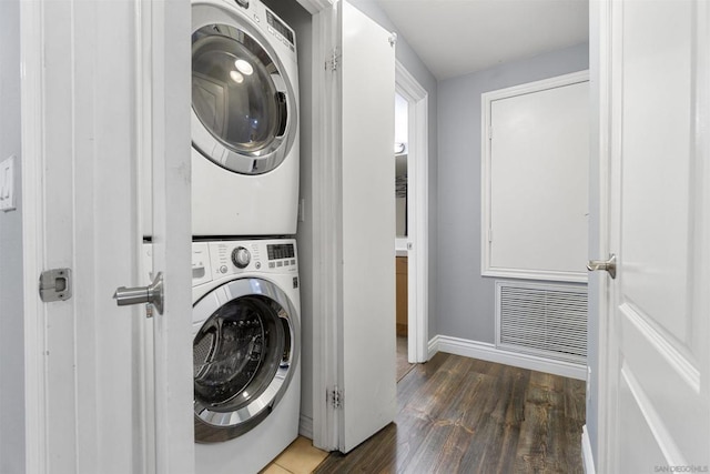 clothes washing area with stacked washer and dryer and dark hardwood / wood-style floors