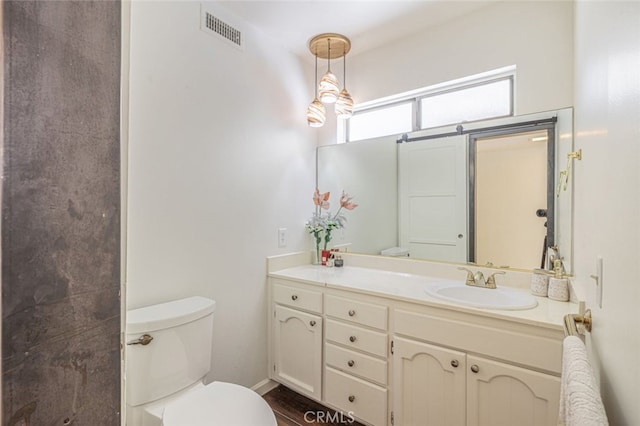 bathroom with toilet, hardwood / wood-style flooring, and vanity