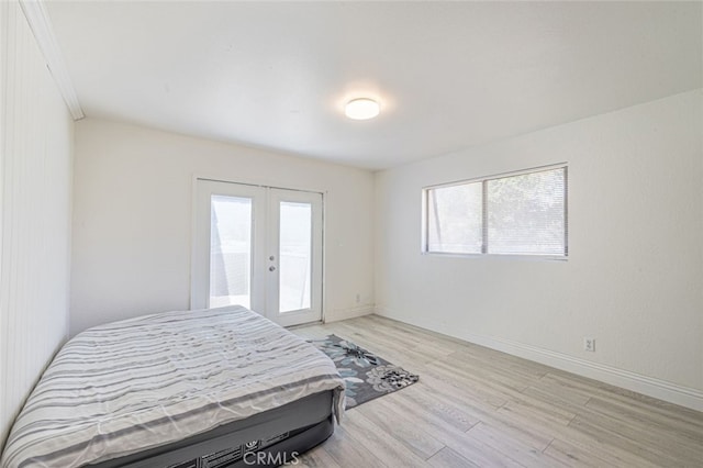 bedroom with french doors and light hardwood / wood-style floors