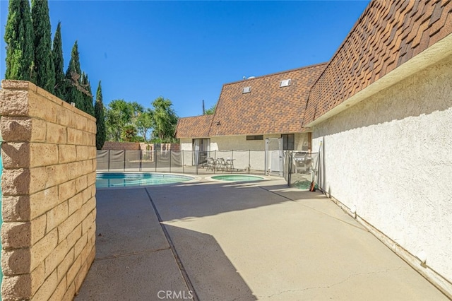 view of swimming pool featuring a patio area and an in ground hot tub