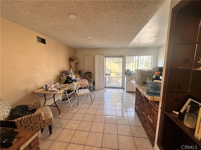 interior space featuring light tile patterned flooring and a textured ceiling