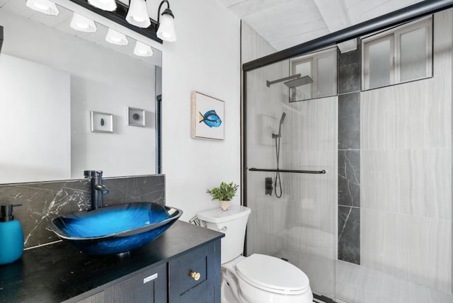 bathroom with toilet, vanity, and an enclosed shower