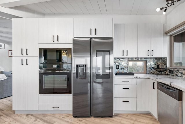 kitchen with light hardwood / wood-style flooring, white cabinets, black appliances, and tasteful backsplash