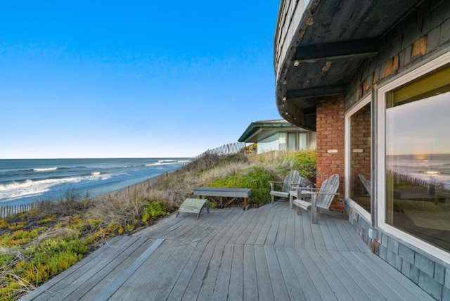 deck with a water view and a beach view