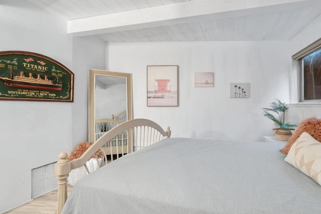 bedroom featuring light hardwood / wood-style flooring and beam ceiling