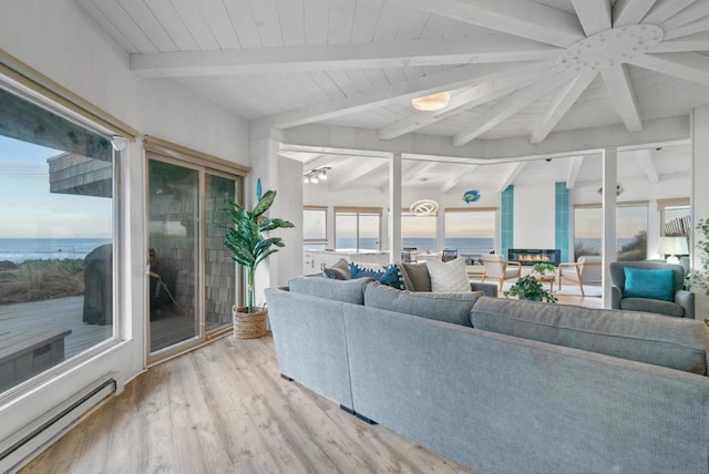 living room featuring a water view, a baseboard heating unit, light wood-type flooring, and ceiling fan