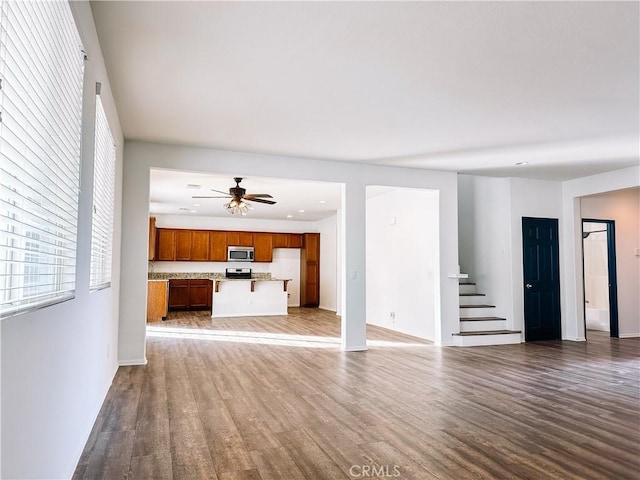 unfurnished living room featuring ceiling fan and wood-type flooring