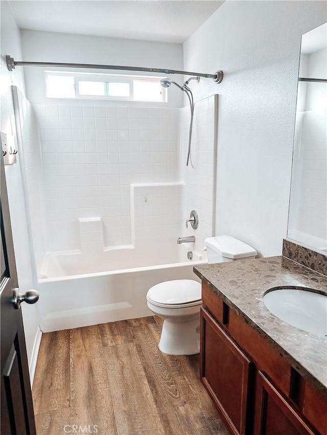 full bathroom with hardwood / wood-style flooring, toilet, vanity, and  shower combination