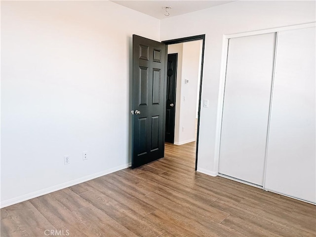 unfurnished bedroom featuring light wood-type flooring and a closet