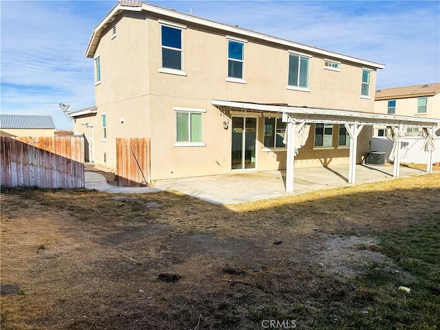 back of property with central AC unit and a patio