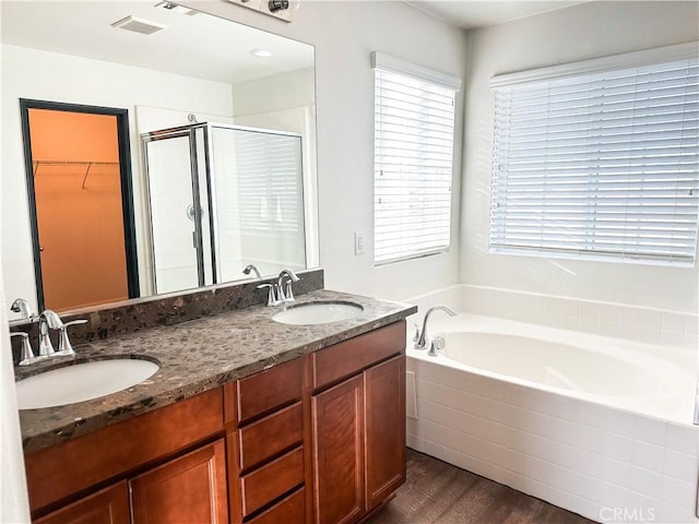 bathroom with hardwood / wood-style flooring, vanity, and shower with separate bathtub