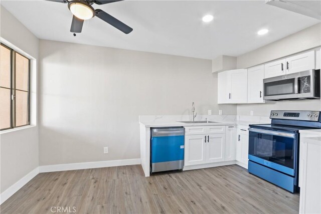 kitchen featuring plenty of natural light, stainless steel appliances, white cabinetry, and sink