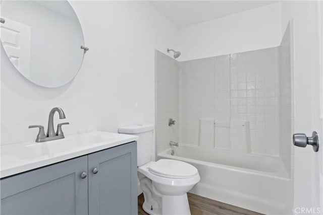 full bathroom with bathtub / shower combination, wood-type flooring, toilet, and vanity